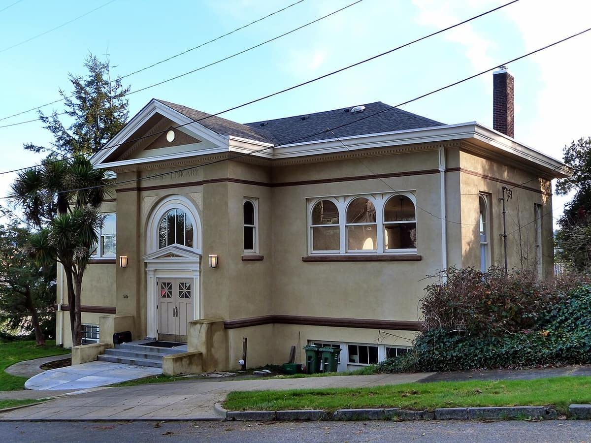 The historic Carnegie Library building in Coos Bay, a stucco building with arched windows