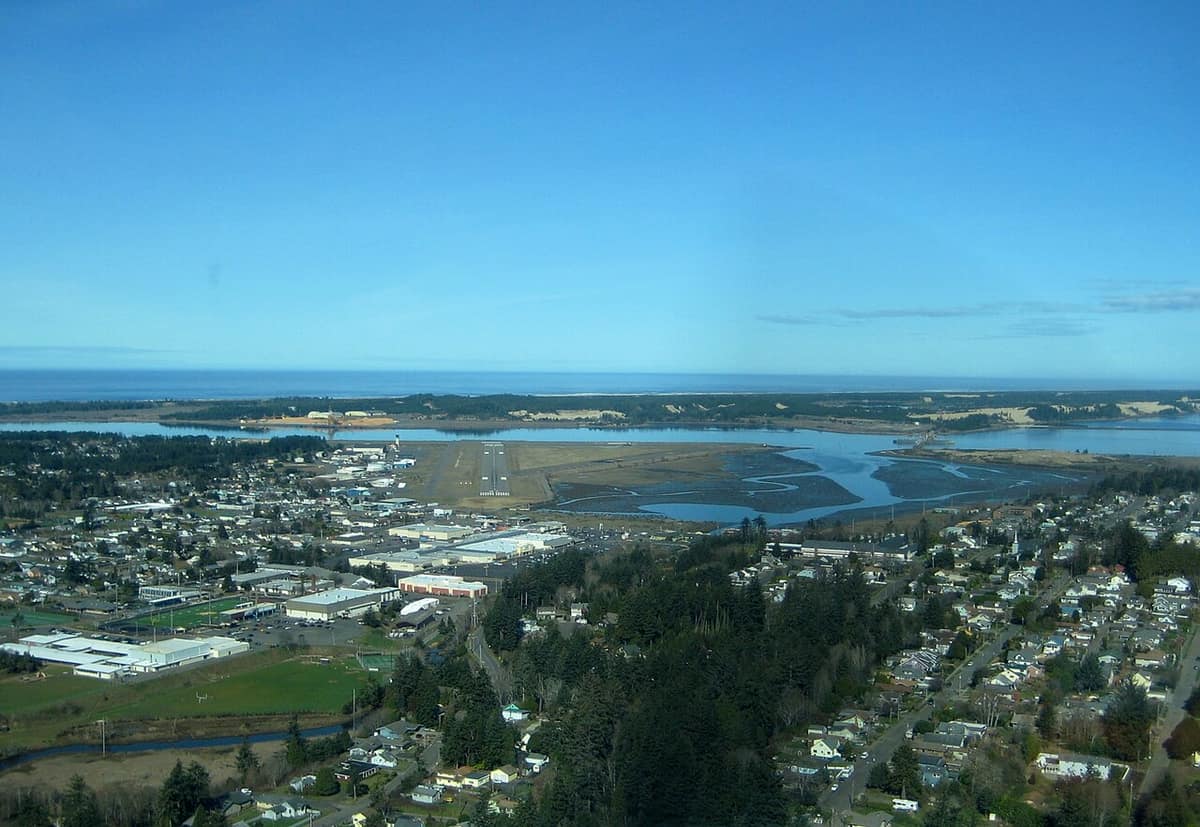 Aerial view of the Coos Bay and North Bend area with the bay, the airport runway and the ocean beyond