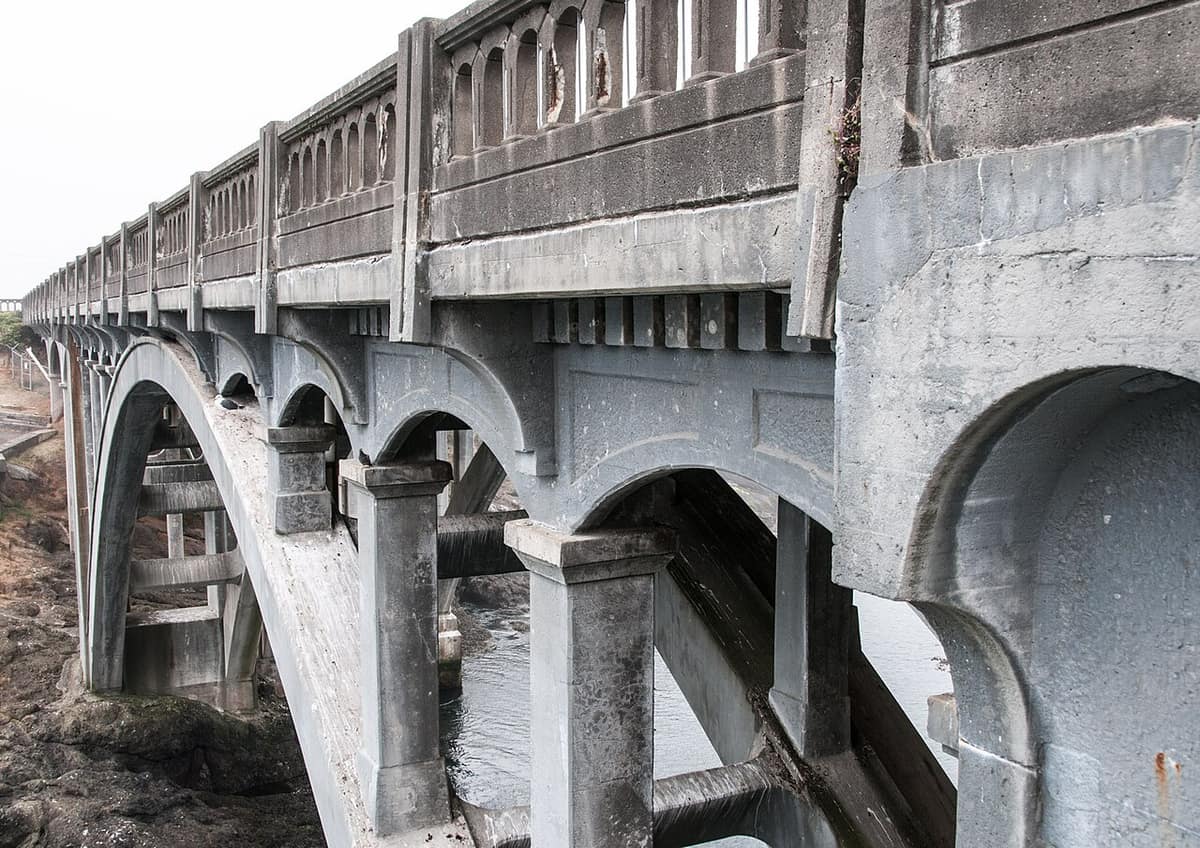 concrete arches of the Depoe Bay Bridge over the harbor channel