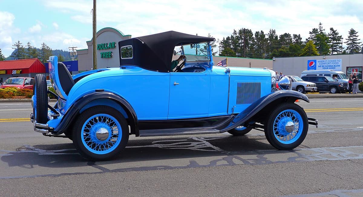 vintage blue roadster driving in the Rhododendron Festival parade in Florence