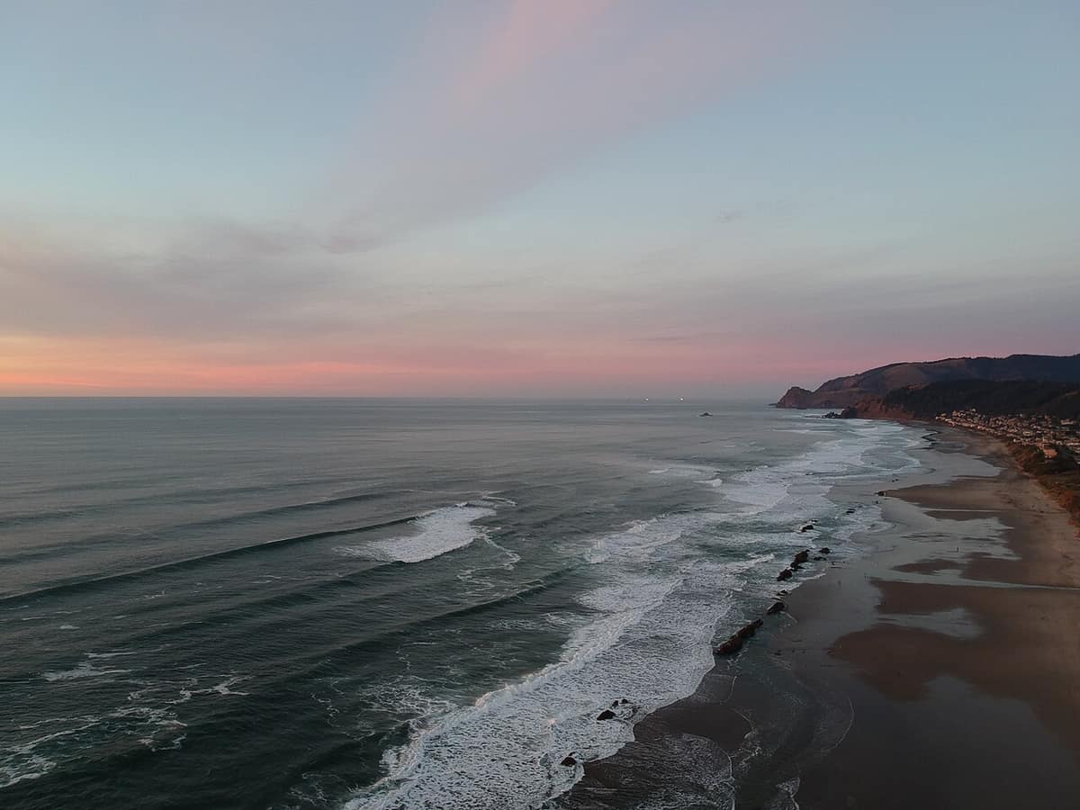 Aerial view of the Lincoln City coastline and surf at dusk