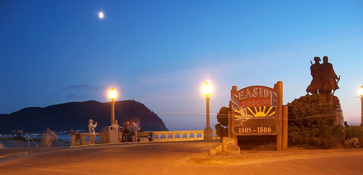 The Seaside sign and Lewis and Clark statue at the Turnaround at dusk, with Tillamook Head behind