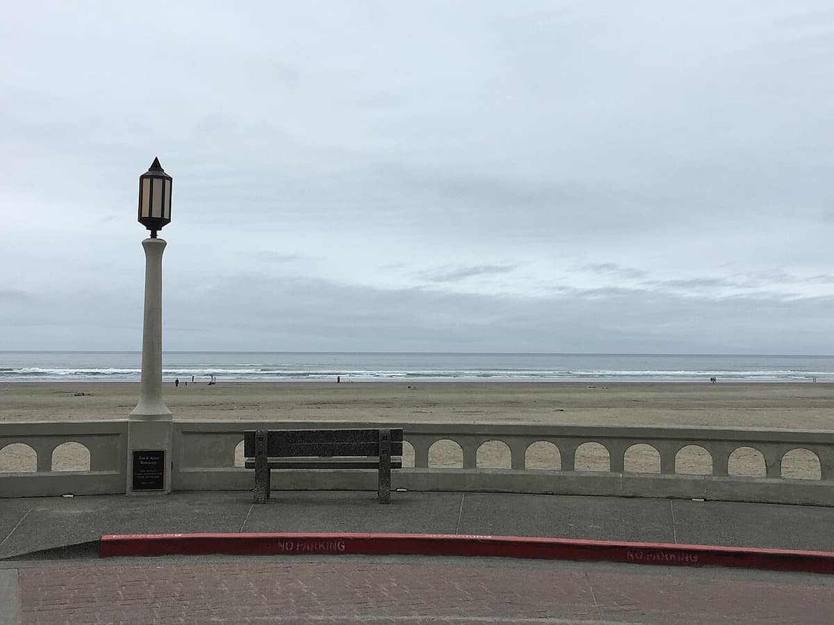 Seaside Prom railing and lamp post overlooking the beach and Pacific on an overcast day